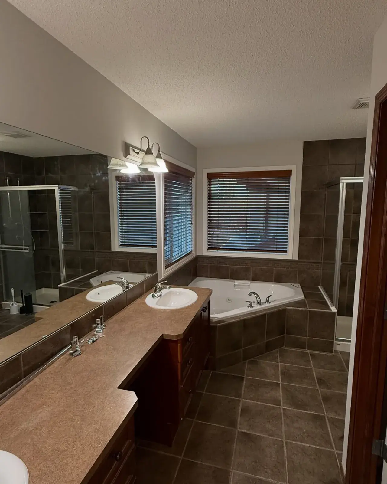 Master bathroom with corner soaker tub and dark tile, finished by Chamos Painting
