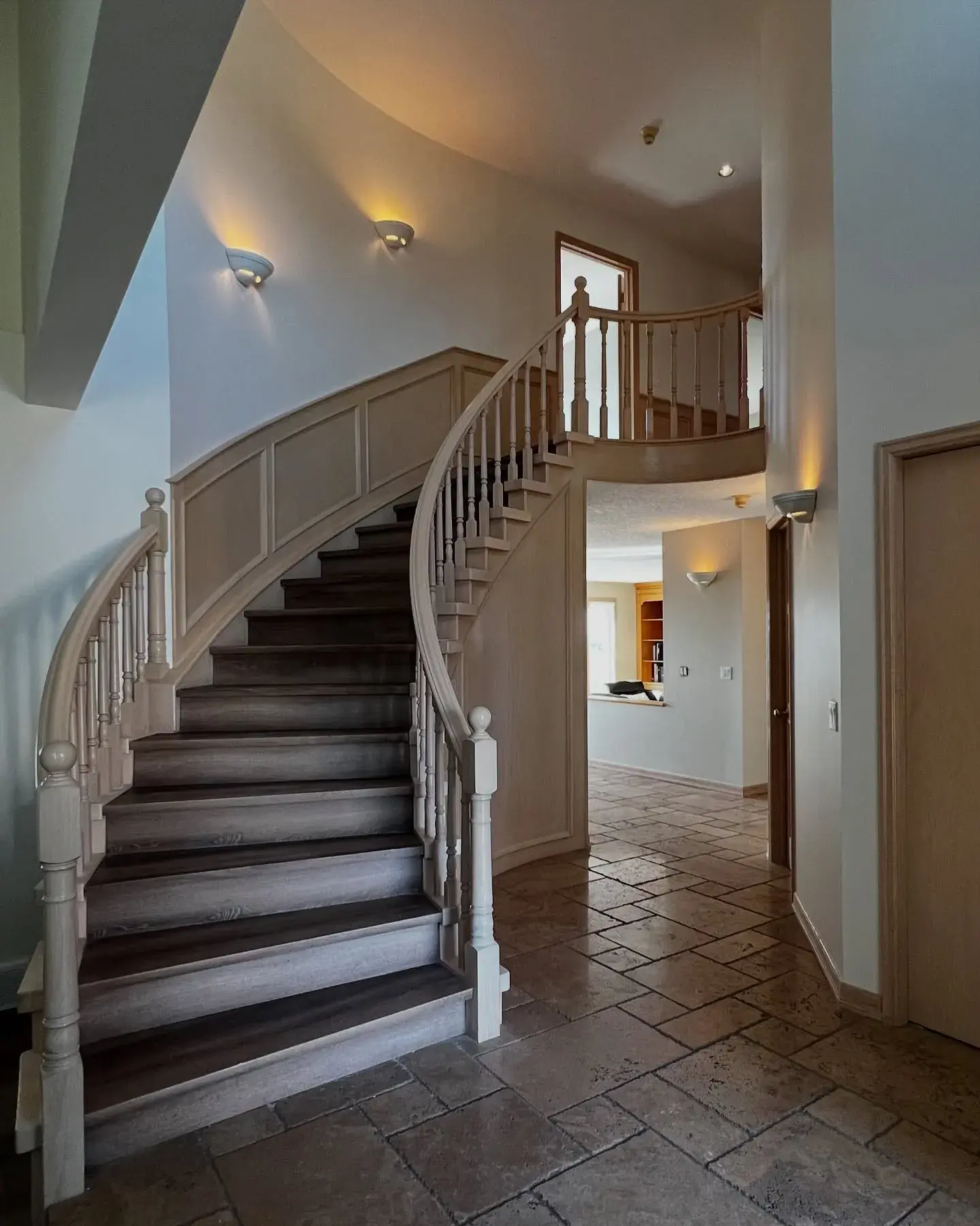 Curved Staircase & Foyer Refinish — A sweeping curved staircase and two-storey foyer painted top to bottom
