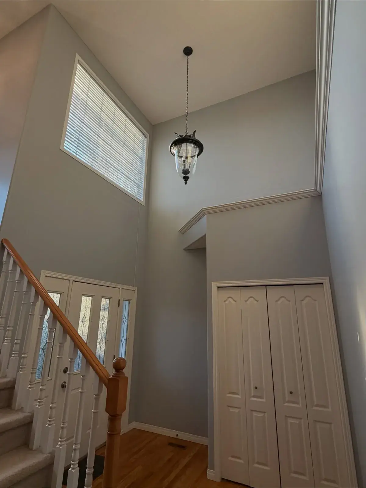 Two-Storey Foyer Repaint — Tall entryway walls and trim painted clean from top to bottom