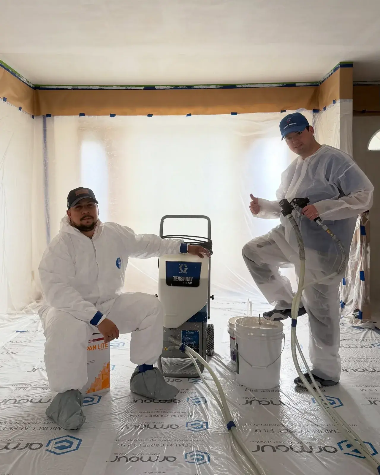 Chamos Painting crew spraying a ceiling on-site at a Calgary home