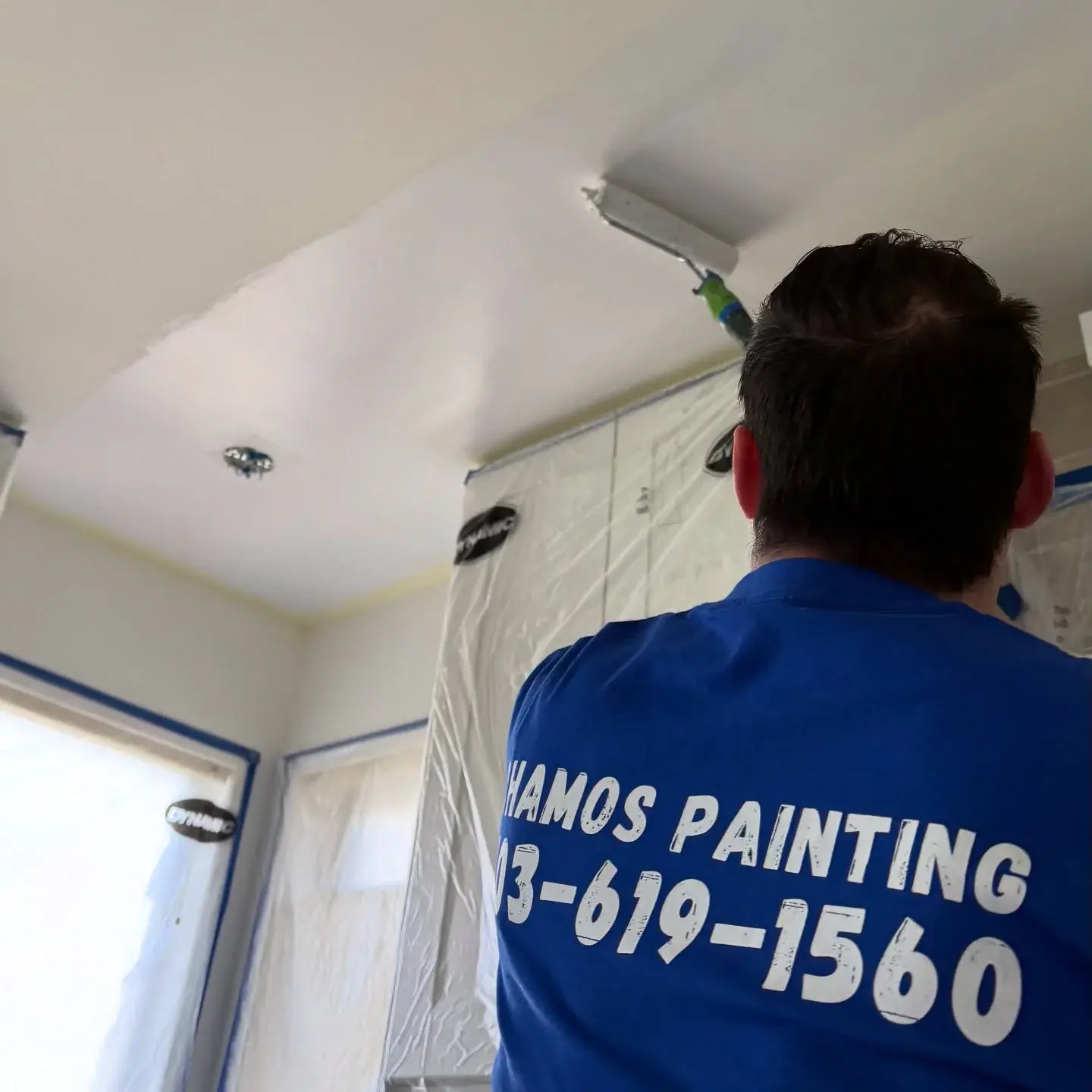 A Chamos Painting team member rolling a fresh coat onto a Calgary ceiling